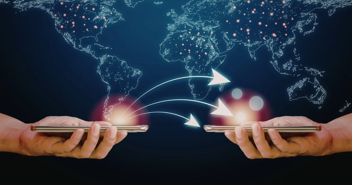 Two people holding smartphones with digital arrows showing international money transfers across a world map.