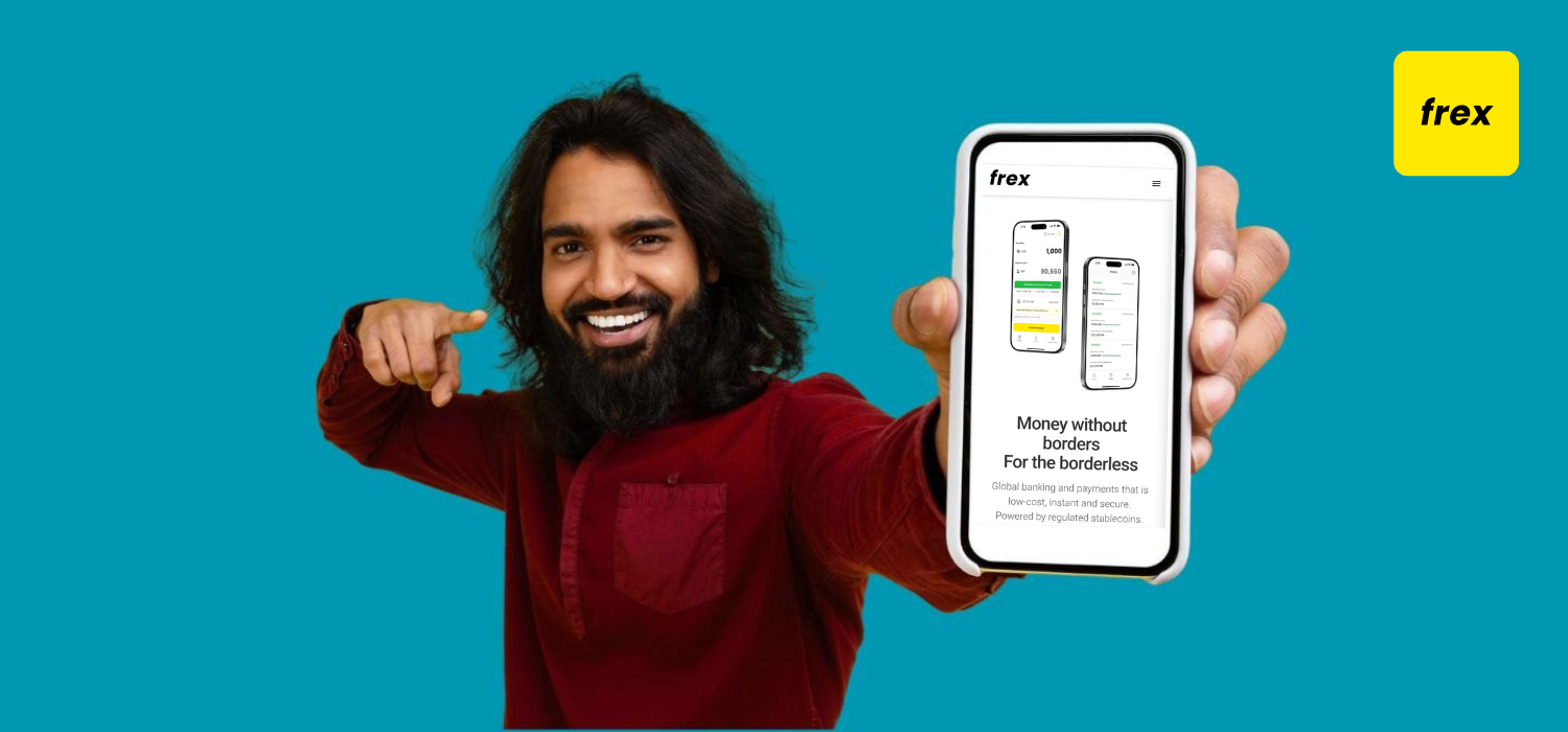 Cheerful young indian man pointing at phone in his hand