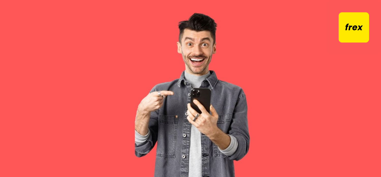 Excited young man pointing at phone